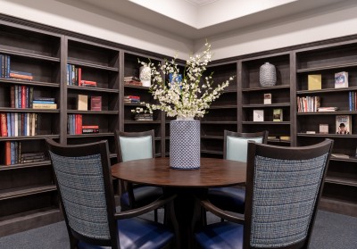 built-in book shelves with books next to round dining table and chairs