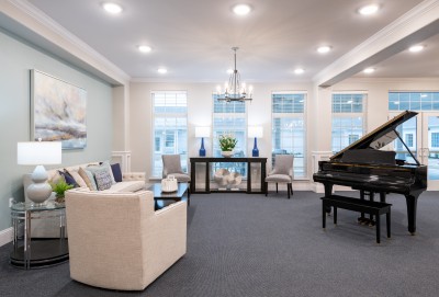large white room with modern decor, seating area and grand piano